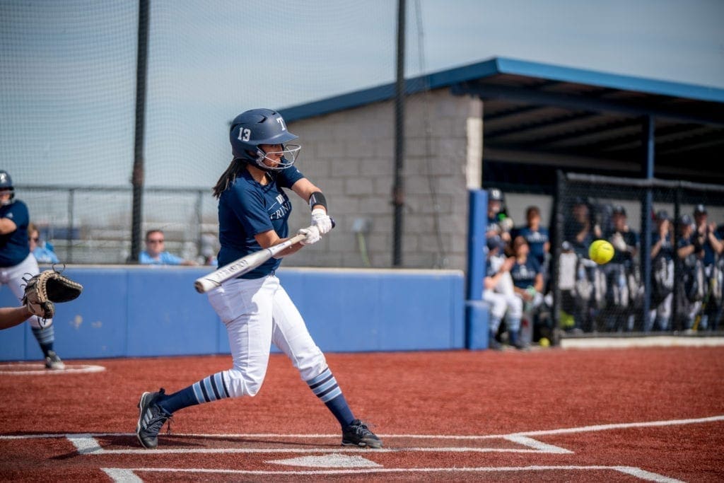 softball player swinging at a pitch